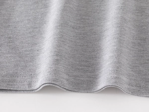 Close-up of gray piqué cotton fabric showing breathable texture and double-stitch hem details