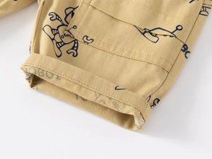 Détail du tissu en coton kaki avec imprimés robot et coutures soignées sur un short enfant