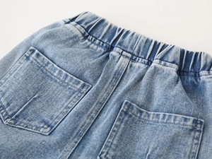 Detail of kids' denim jeans showing the elastic waistband and dual back pockets