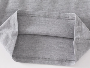 Detailed macro view of gray pique cotton hem with durable double-needle stitching on boys polo