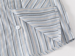 Détail de tissu en coton à rayures bleues et brunes avec bouton en résine blanc