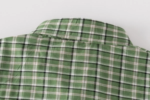 Detail of green plaid cotton fabric and fine stitching on boy's summer casual shirt