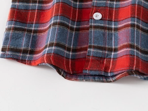 Détail de l'ourlet de chemise en flanelle à carreaux rouge et bleu avec bouton blanc doux