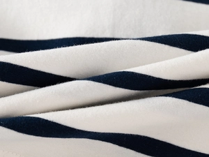 Dettaglio del morbido tessuto in maglia di cotone a righe blu e bianche per polo bimbo