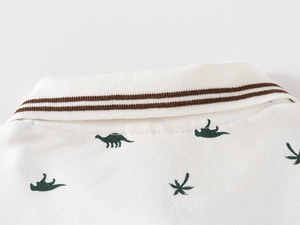 Detailed view of kids white polo shirt collar with ribbed texture and dinosaur print