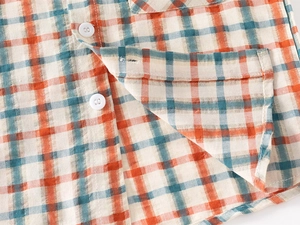 Detailed macro view of retro plaid shirt fabric texture with white buttons and stitching