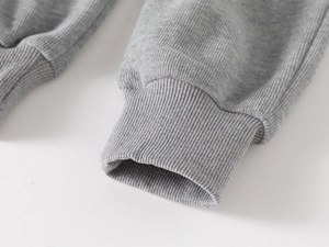 Detailansicht der Rippbündchen an grauen Kinderhosen mit feiner Nahtverarbeitung