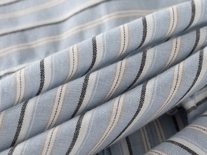 Détail macro du tissu en coton rayé respirant montrant la texture tissée bleue et brune