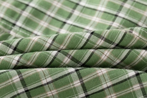 Close-up of green and white plaid cotton fabric showing detailed woven texture and pattern