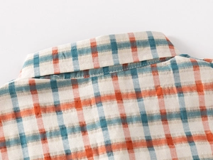 Detailed macro view of the plaid cotton shirt collar with orange and teal checked pattern