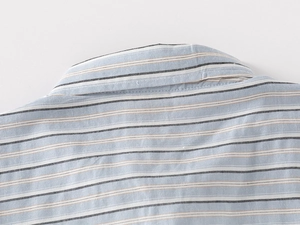 Gros plan du col et de la texture en lin respirant d'une chemise rayée pour garçons