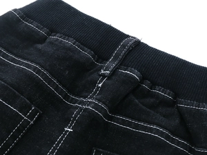 Close-up of kids black denim jeans featuring elastic waistband and white contrast stitching