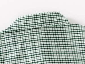 Detail of green and white plaid kids shirt collar with fine textured fabric view