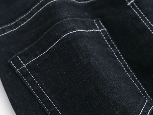 Detail of black denim fabric with white contrast stitching and rear pocket workmanship