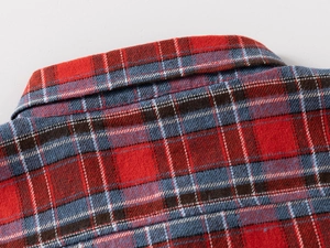 Macro détaillée du col d'une chemise en flanelle à carreaux montrant les coutures