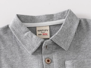Detail of grey kids polo shirt collar with wooden buttons and soft knit texture