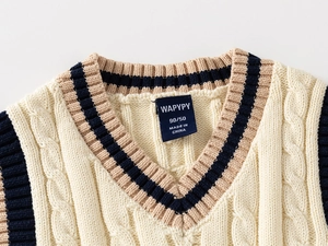 Detail of kids V-neck cable knit vest showing cream fabric and striped trim accents