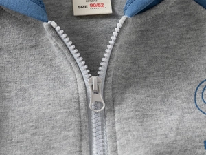 Detail of gray kids hoodie showing smooth white resin zipper and soft cotton knit fabric