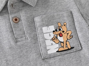 Close-up of polo collar with wood button and cartoon dog embroidery on grey fabric