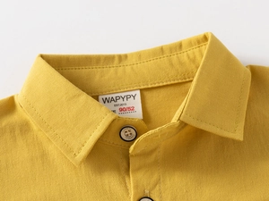 Detailed macro view of mustard yellow cotton kids shirt with square collar and button
