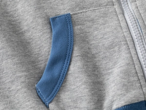 Detailed close-up of zipper, side pocket, and contrast stitching on toddler hoodie
