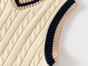 Detailed view of cable knit pattern and contrast striped V-neck on child's vest