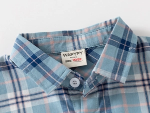 Detailed close-up of the collar on this blue plaid cotton shirt for boys with buttons