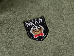 Close-up of olive fleece jacket with high-quality bear embroidery and soft fabric texture