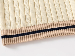 Detail of cable knit pattern and elastic ribbed hem on kids knit vest in beige and khaki