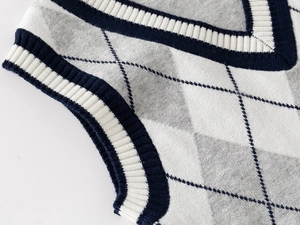 Detailed close-up of V-neck collar and blue argyle knit pattern on children vest