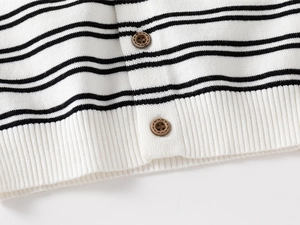 Close-up of black and white striped knit cardigan featuring brown wooden buttons and ribbed hem