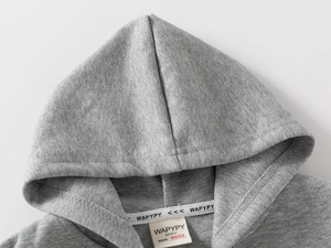 Détail de la doublure de capuche en coton et de l'étiquette sur le sweat gris garçon