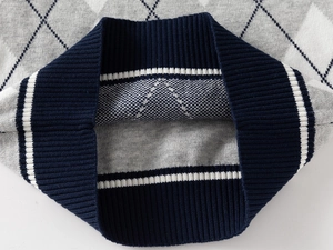 Detailed view of the ribbed hem and argyle knit pattern on the boys sweater vest