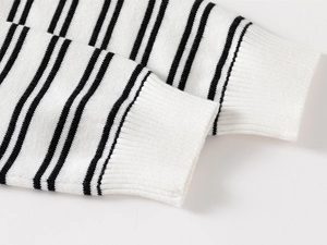 Detailed close-up of black and white striped ribbed cuffs on a knitted sweater