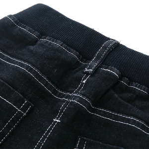 Kids black denim pants featuring elastic ribbed waistband and contrast white stitching