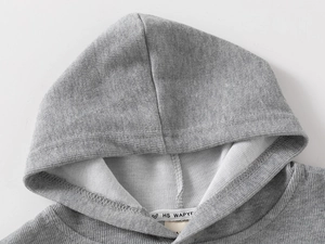 Close-up of baby gray hoodie showing soft cotton texture and inner neckline labels