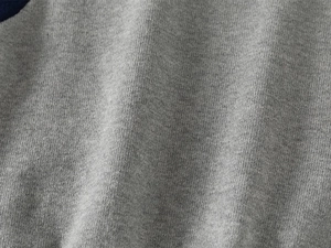 Close-up detail of grey knitted cotton fabric texture on boys autumn sweater
