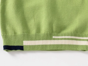 Detail of green knitted vest featuring ribbed hem and contrasting white and navy stripes