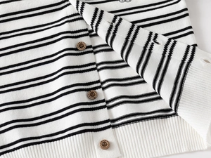 Detail of black and white striped knit cardigan with vintage wooden buttons and ribbed hem