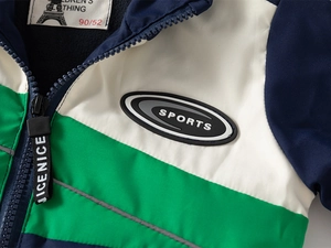 Détail d'une veste polaire pour enfant montrant la fermeture éclair et le badge