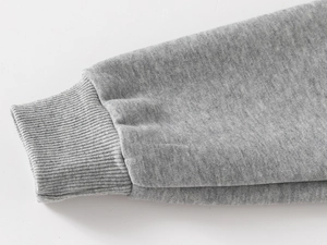 Détail des poignets côtelés du sweat à capuche dinosaure gris en coton tricoté de qualité