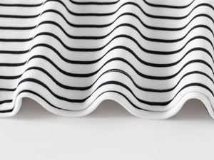Detail of double-needle stitching on hem of black and white striped cotton kids polo