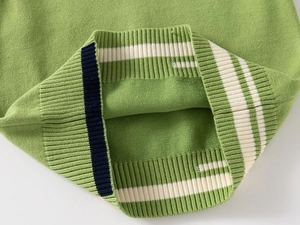 Detailed macro view of the green ribbed knit hem with classic athletic striped trim