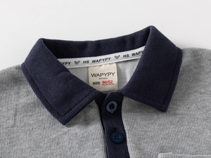 Detail of children's grey knit polo collar with navy blue contrast and brand size label