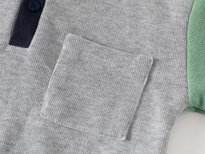 Detailed close-up of boy's knitted sweatshirt showing fabric texture and contrast pocket