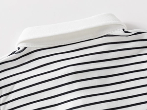 Detailed close-up of children's polo shirt featuring black and white horizontal stripes