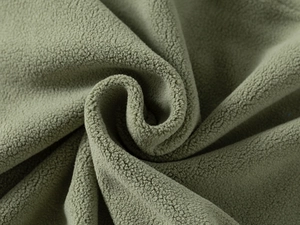 Macro detail of soft olive green fleece fabric texture with warm and thick polar fleece fibers