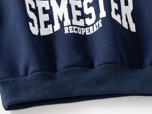 Close-up of navy blue sweatshirt showing ribbed hem and white SEMESTER print