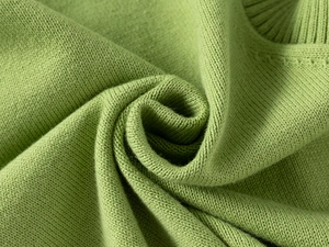 Close-up of bright green knitted fabric showing detailed ribbed texture and soft material