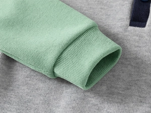 Detail of green ribbed cuffs and grey knit fabric on children's fashion sweatshirt